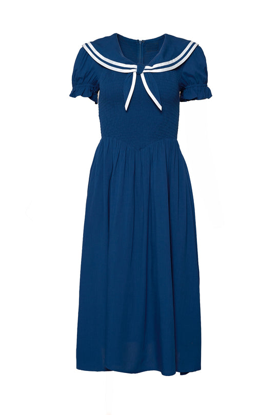 The Alice Dress in Sailor Navy by Ivy City Co is a knee-length, blue dress with short puff sleeves, a gathered waist, and a white sailor collar with two stripes—perfect as a summer midi dress.