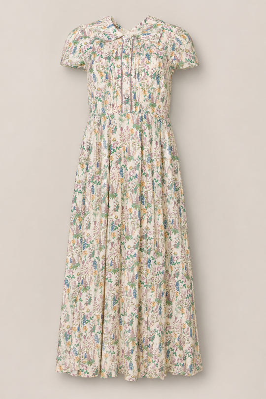 The Amber Dress in Autumn Bouquet by Ivy City Co features a vintage-inspired design with short sleeves, a tea-length silhouette, and a soft floral print. Its fitted bodice, front buttons for nursing-friendly access, and gathered skirt add timeless charm to any occasion.