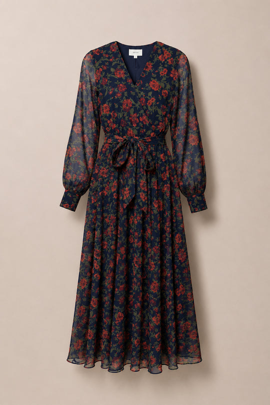 The Andie Dress in Scarlet Blooms by Ivy City Co features a navy blue long-sleeve midi design with a vibrant red floral print, V-neckline, fitted waist with a matching tie belt, and a flowing, sheer fabric skirt. Nursing-friendly and effortlessly elegant, it’s the perfect choice for any occasion.