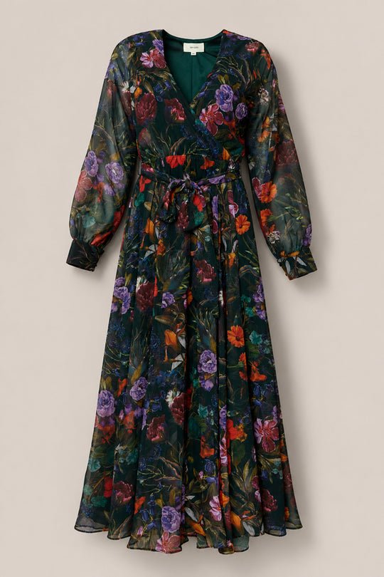 The Andie Dress in Evergreen Vivid Meadow by Ivy City Co is a long-sleeve, floor-length chiffon maxi dress with a deep V-neck and belted waist. Featuring sheer fabric with a dark green background decorated with vibrant red, purple, and orange floral prints, this elegant silhouette is designed to be nursing friendly.