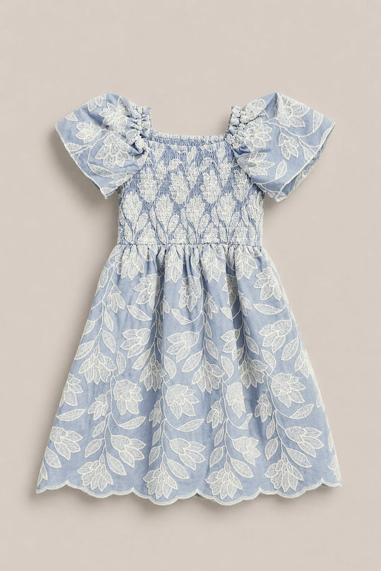 The Mini Ophelia Dress in Mosaic Embroidery by Ivy City Co is a light blue toddler dress featuring a smocked bodice, puff sleeves, and delicate white mosaic embroidery throughout. Scalloped edges on the skirt and sleeves add an elegant touch, making it a charming choice for Mom and Me matching moments.