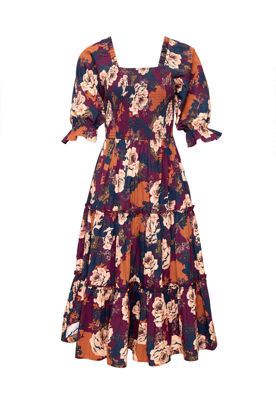 The Ivy City Co Madeline Dress in Equinox Rose is a maternity-friendly, floral-patterned midi dress featuring puffed short sleeves, a square neckline, and a tiered skirt in vibrant shades of orange, purple, and cream.