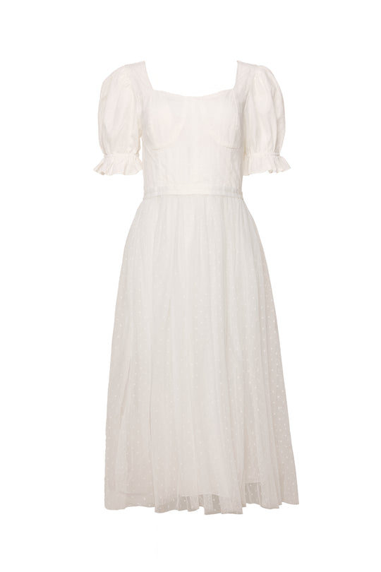 The Ballerina Dress in White by Ivy City Co features puff sleeves, a fitted bodice, and a flared semi-sheer skirt with a subtle dotted pattern and ruffled sleeve hems for an elegant, ballet-inspired look.