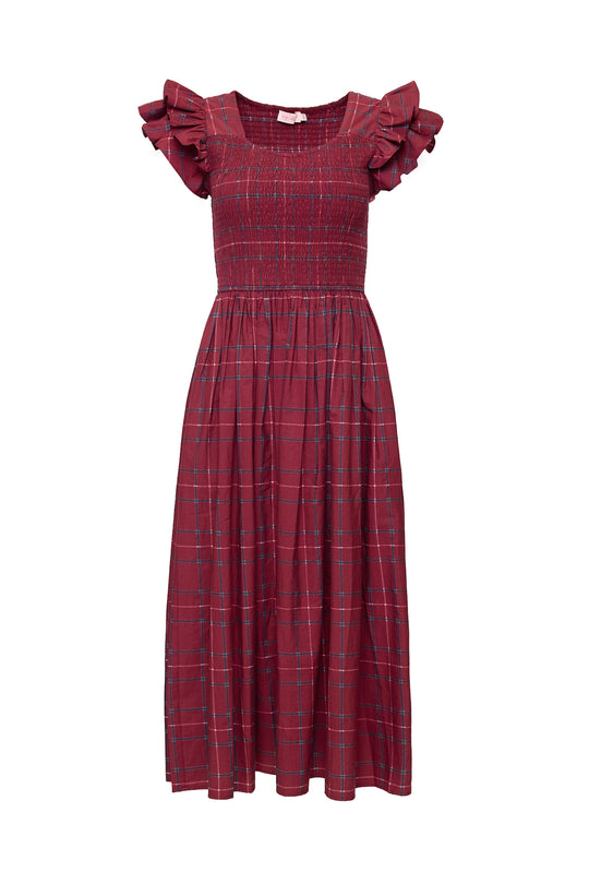 The Hattie Dress in Burgundy Plaid by Ivy City Co features a sleeveless design, smocked bodice, ruffled shoulder straps, and a gathered midi-length skirt.