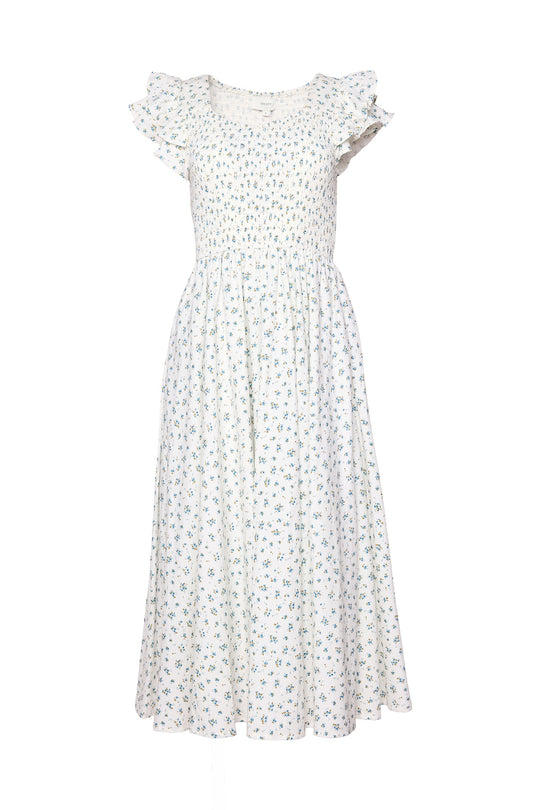The Hattie Dress in Madeline Blue by Ivy City Co is a white, ankle-length cotton midi dress with a smocked bodice, short ruffled sleeves, and a delicate blue and green floral print. Its flowy skirt highlights the feminine, summery style.