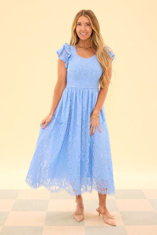 Woman wearing a light blue lace dress on a beige background