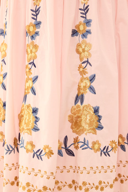 Floral embroidery on a pink fabric background