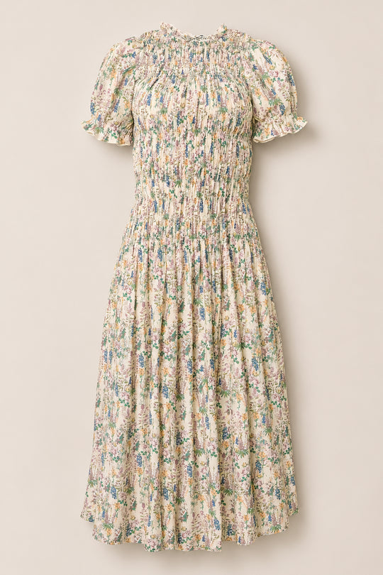 The Jennifer Dress in Autumn Bouquet by Ivy City Co is a light cream dress adorned with a floral print, featuring short puff sleeves, a smocked bodice for comfort, and a gathered midi-length skirt. Maternity friendly and effortlessly elegant, it’s showcased against a plain background.