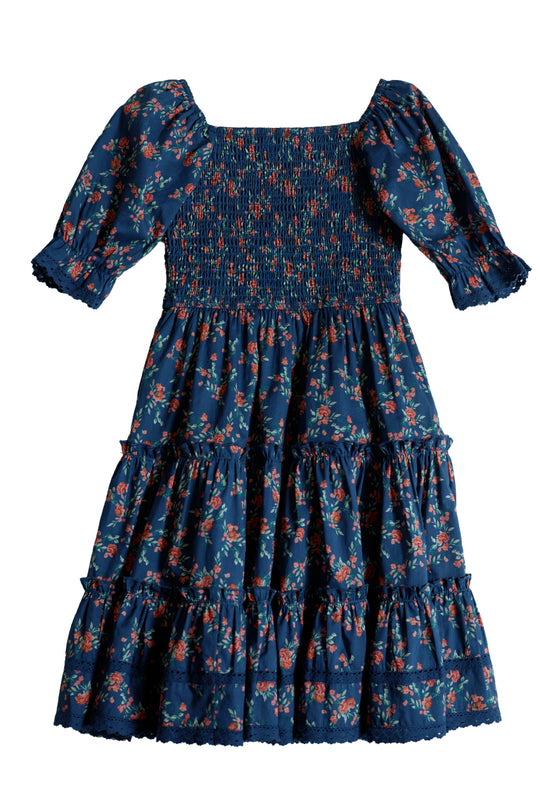 The Ivy City Co Mini Madeline Dress in Midnight Vibrant Chintz is a girls' knee-length dress featuring short puff sleeves, a smocked bodice, tiered skirt, and a colorful red and green floral chintz print.