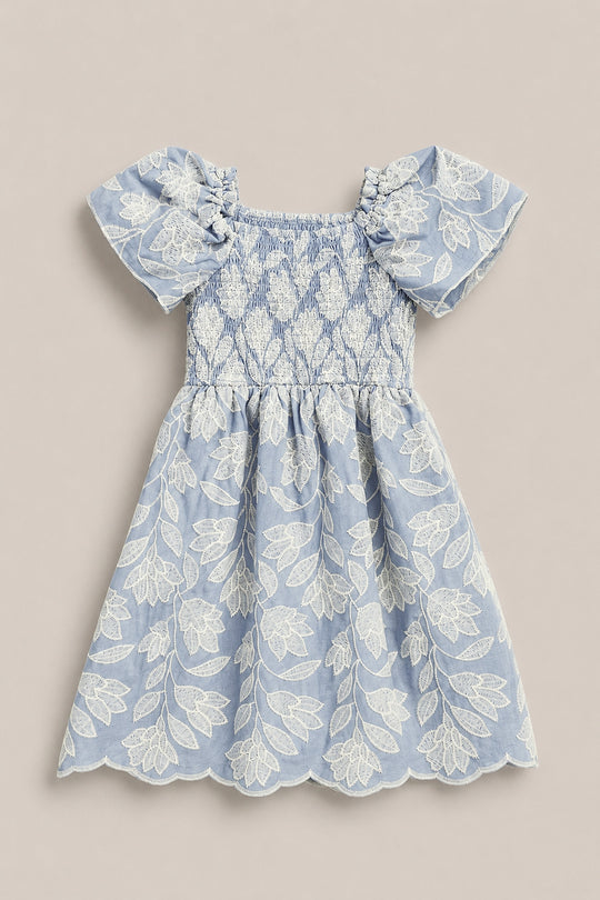 The Mini Ophelia Dress in Mosaic Embroidery by Ivy City Co features a light blue hue, white mosaic embroidery, puffed sleeves, smocked bodice, and scalloped hems. Shown laid flat on a neutral background. Perfect for Mom and Me matching looks.