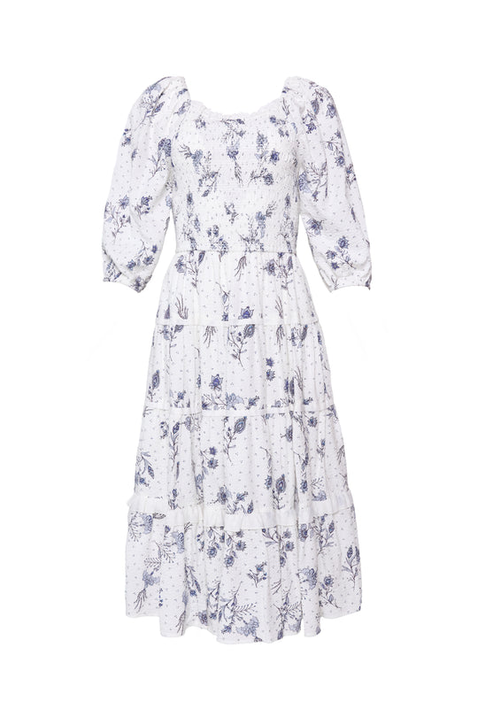 The Roselyn Dress in Blue Enchanted Floral by Ivy City Co is a white, knee-length dress with blue florals, puffed three-quarter sleeves, a tiered skirt, and a maternity-friendly design.