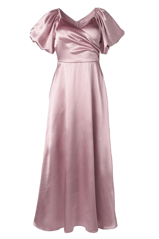 The Tessie Dress in Blush by Ivy City Co is a long, elegant pink satin maxi with short puff sleeves, a V-neckline, fitted waist, soft sheen, and floor-length flow—perfect as a bridesmaid dress.