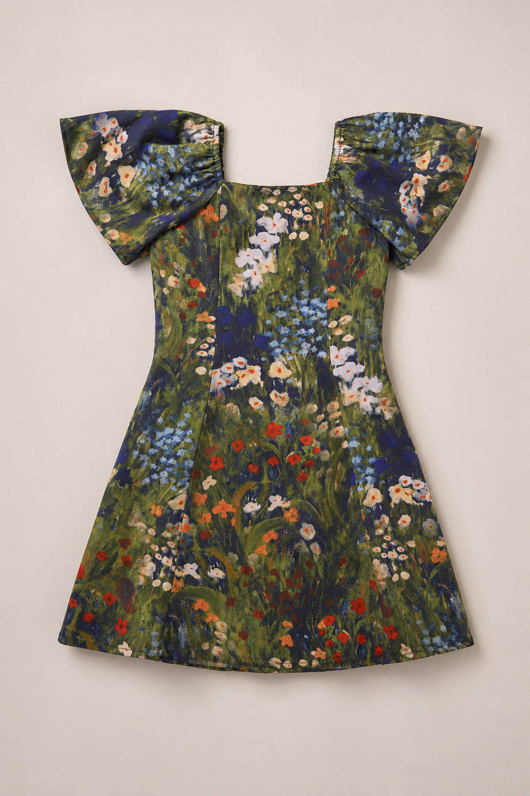 Introducing the Ivy City Co Teen Blakely Flutter-Sleeve Dress in Impressionist Bloom: this short-sleeve dress features flared flutter sleeves and a square neckline, adorned with a vibrant floral print of red, blue, white, and orange blooms against a green background. Displayed laid flat on a beige surface, it’s the perfect addition to your fall wardrobe.