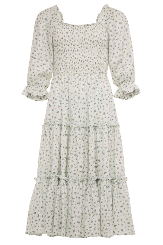The Madeline Dress in Blue by Ivy City Co is a blue, long, tiered floral midi dress with a smocked bodice, three-quarter puff sleeves with ruffled cuffs, and a square neckline—an effortlessly maternity friendly style.